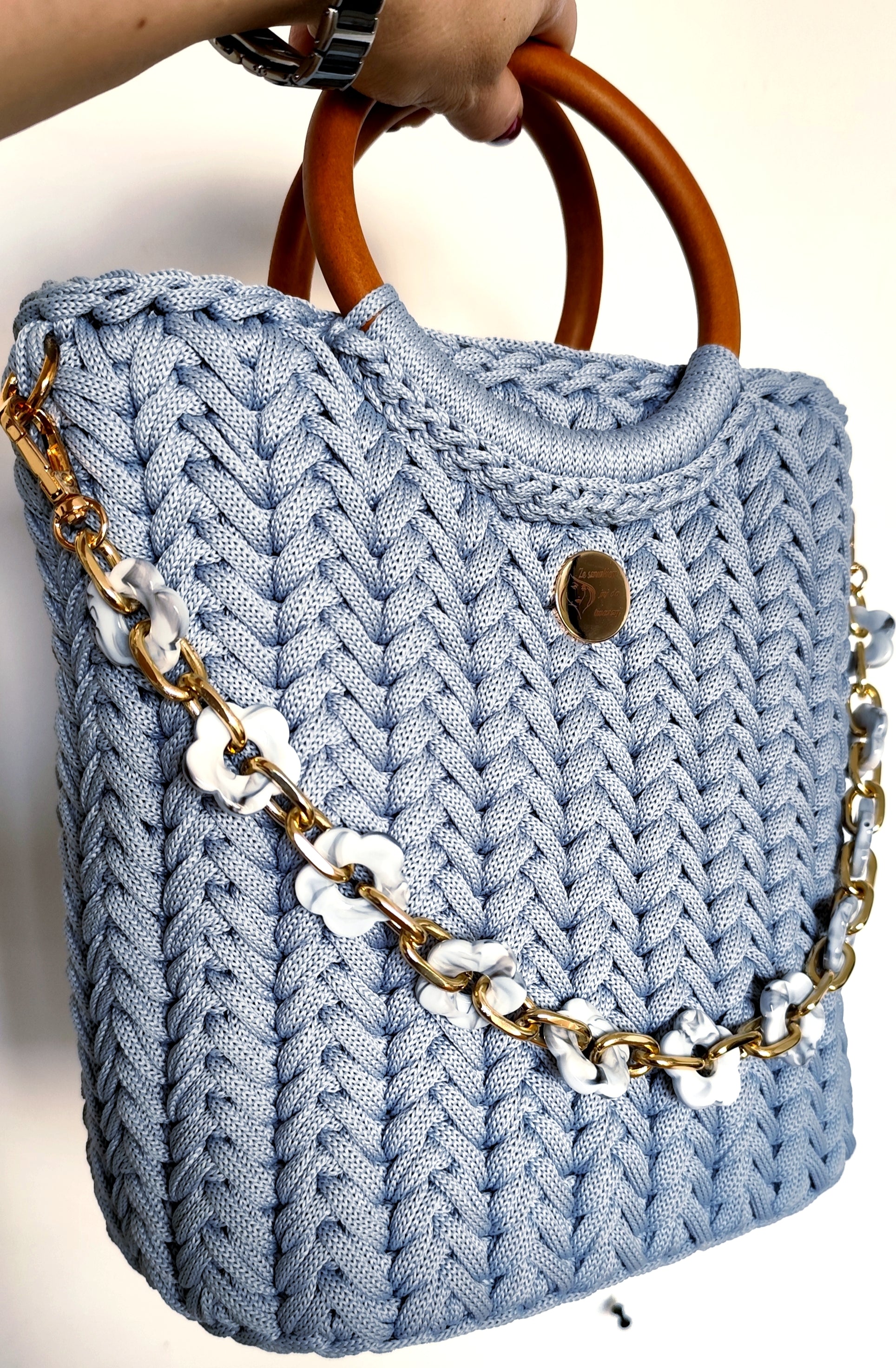 Torebka kuferek Błękitna cisza ze sznurka trzymana w dłoni - widok z przodu z drewnianymi rączkami